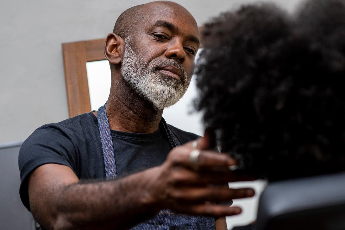 Coiffeur noir analysant cheveux crépus