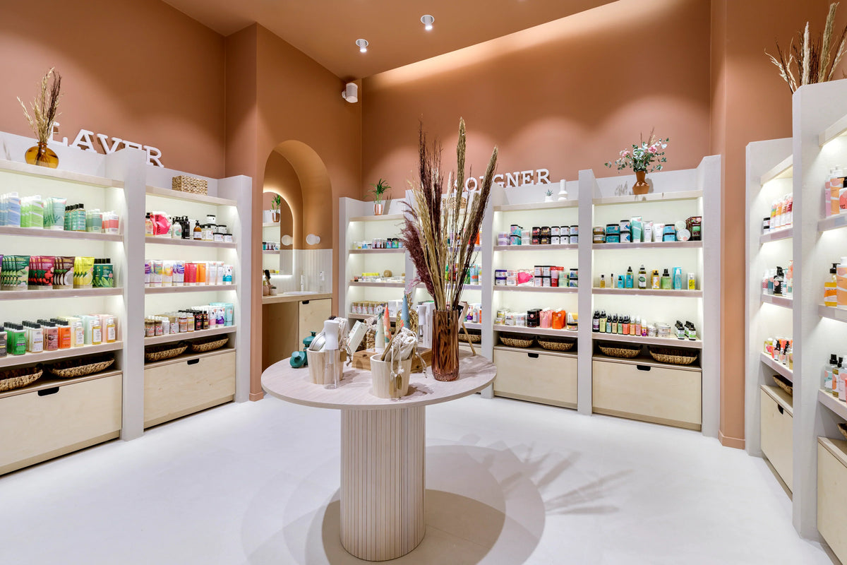Espace boutique de La Belle Boucle Studio, étagères de soins pour cheveux bouclés