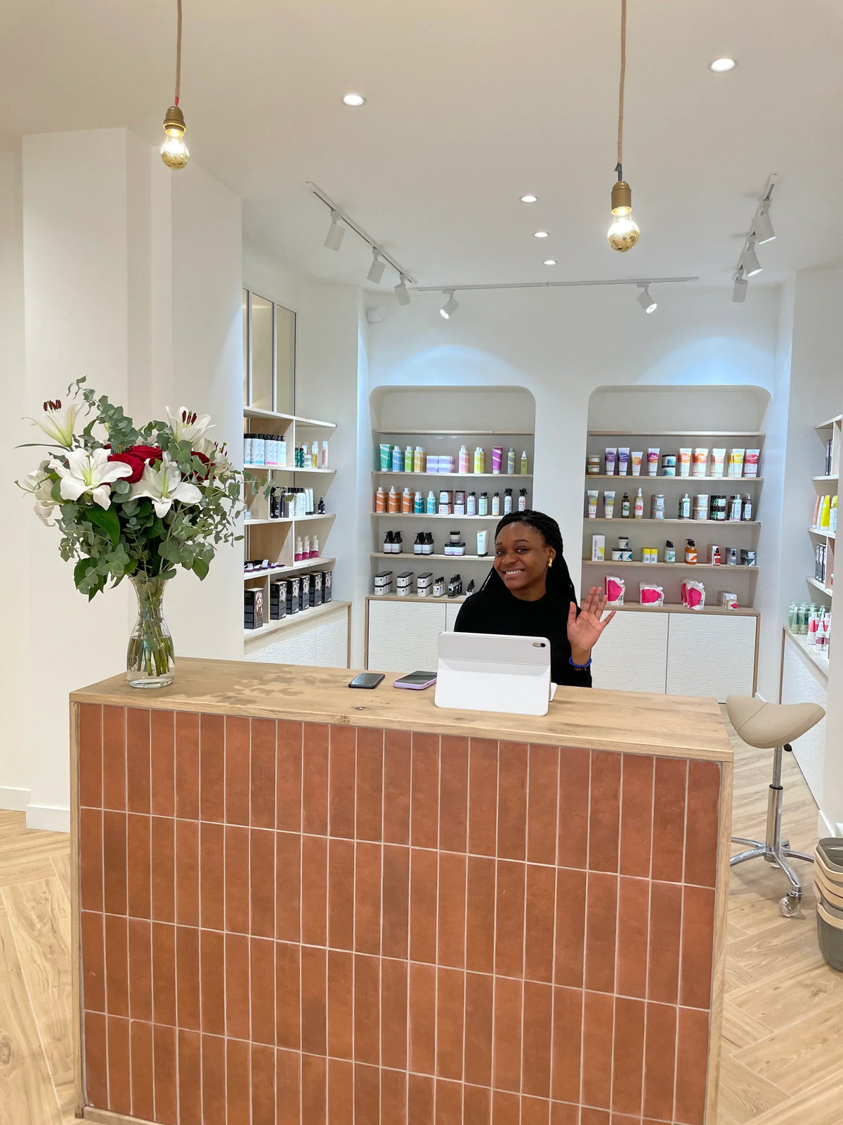 Accueil du salon Baraboucle à Paris, comptoir en brique et étagères de soins