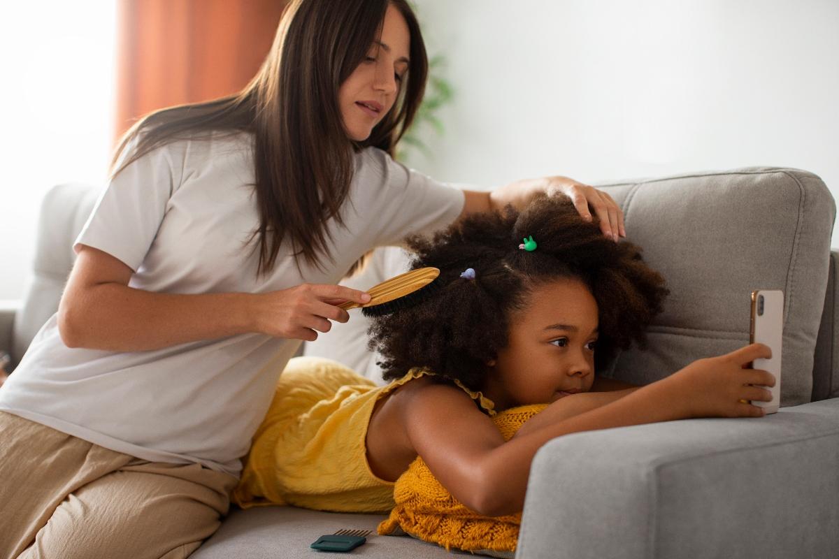 Femme blanche qui coiffe son enfant
