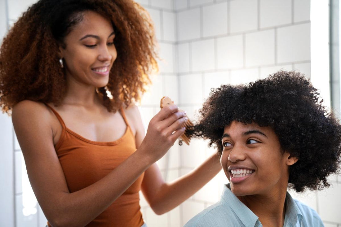 Femme qui démêle les cheveux bouclés