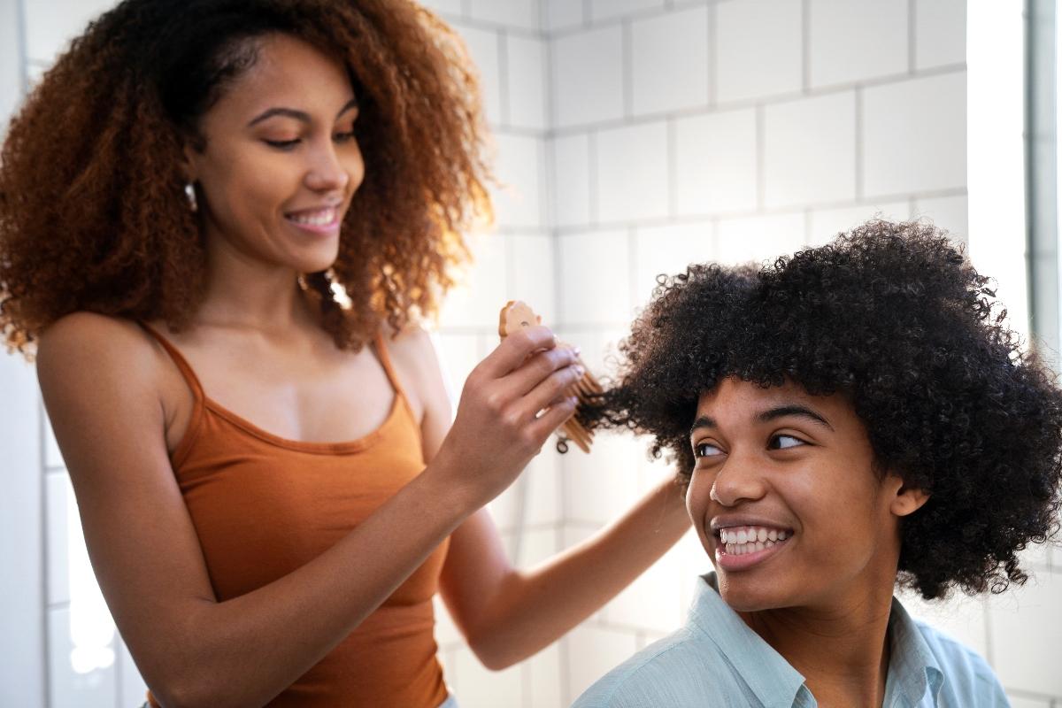 Femme qui démêle les cheveux bouclés