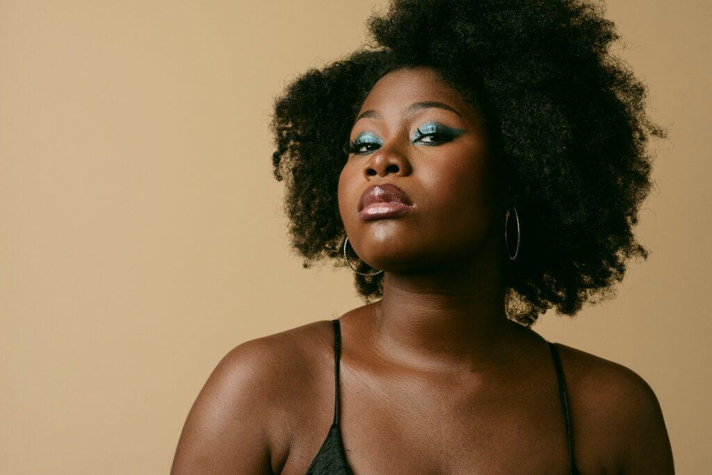 Femme aux cheveux crépus, coiffure afro mettant en valeur la forme du visage