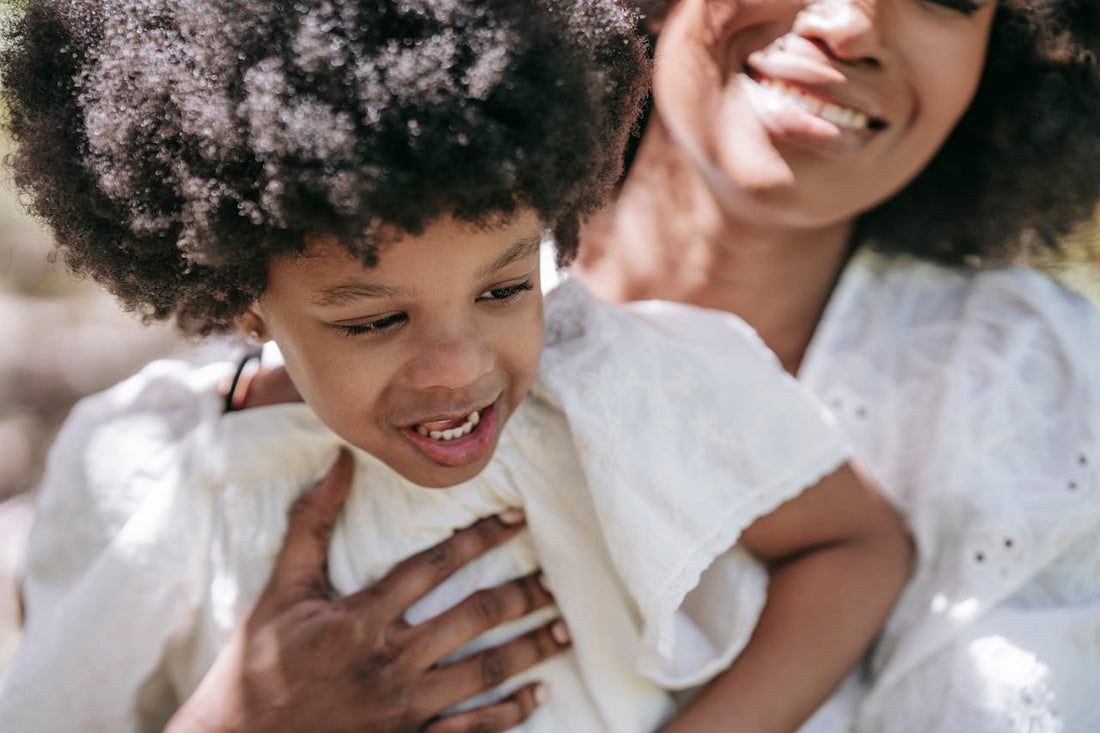 Mère serrant contre elle une petite fille aux cheveux crépus